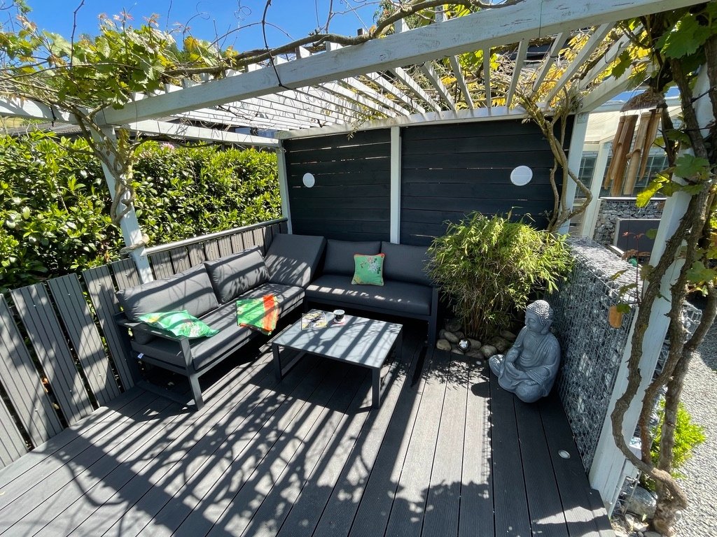 Terrassenlounge unter der begrünten Pergola